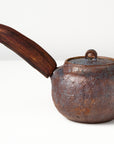 Side handle tea pot with wooden handle on white background. back view