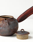 Side handle tea pot with wooden handle on white background. front view with lid off