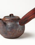Side handle tea pot with wooden handle on white background. angled view