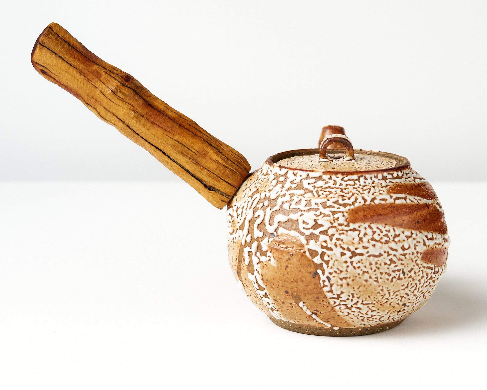 Ceramic teapot with wooden handle on a white background, back view