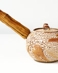 Ceramic teapot with wooden handle on a white background, back view