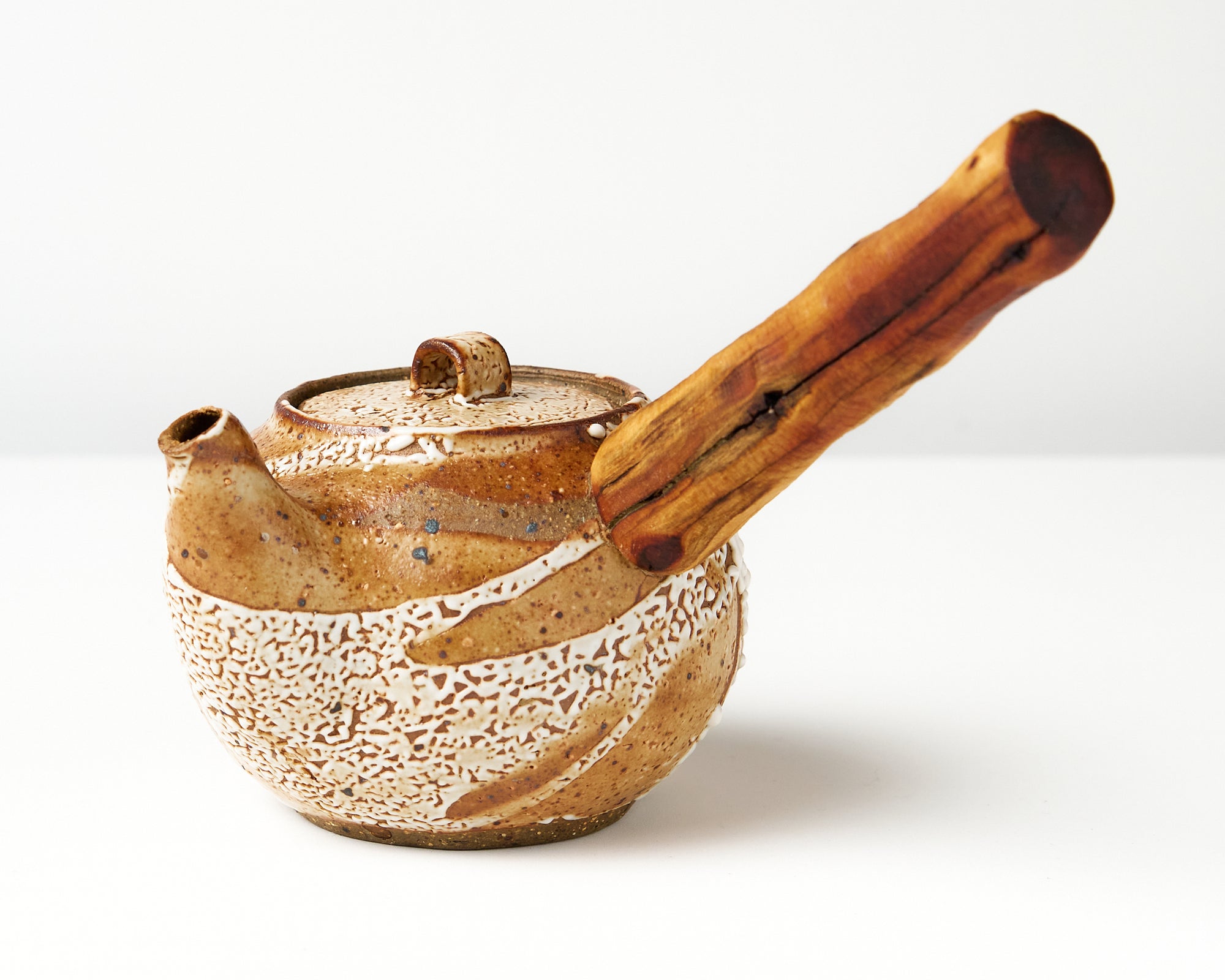 Ceramic teapot with wooden handle on a white background, angled view