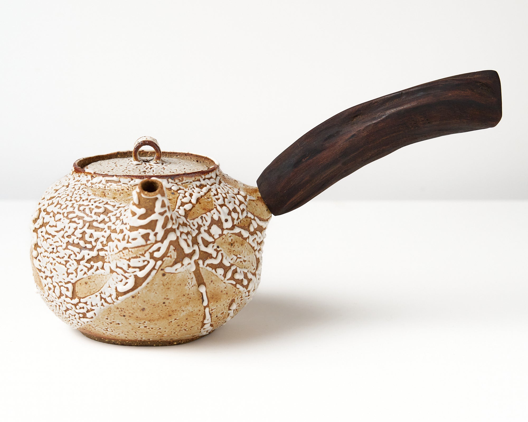Ceramic teapot with a wooden handle on a white background, front view