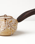 Ceramic teapot with a wooden handle on a white background, front view