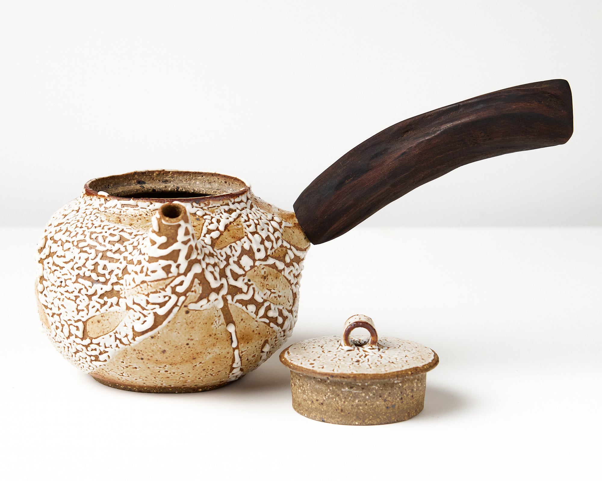 Ceramic teapot with a wooden handle on a white background, front view with lid off