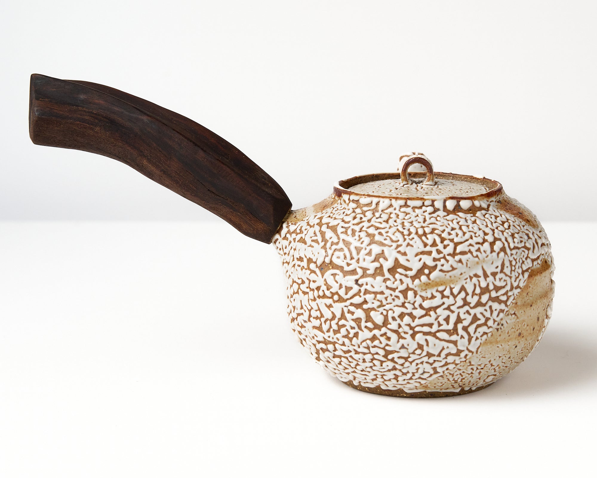 Ceramic teapot with a wooden handle on a white background, back view
