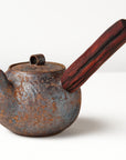 side handle tea pot with wooden handle on white background, angled view