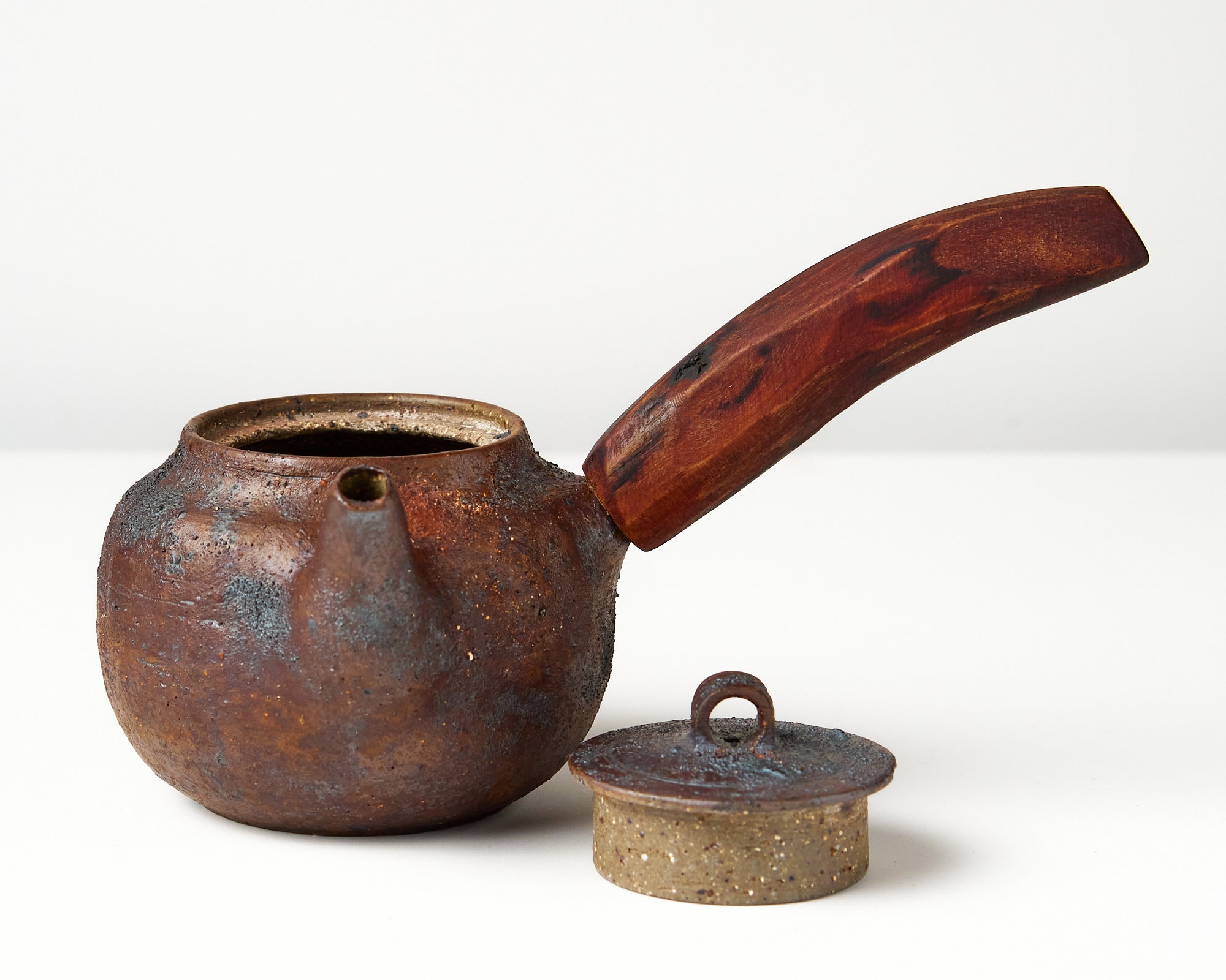 Side handle tea pot with wooden handle on white background. front view with lid off