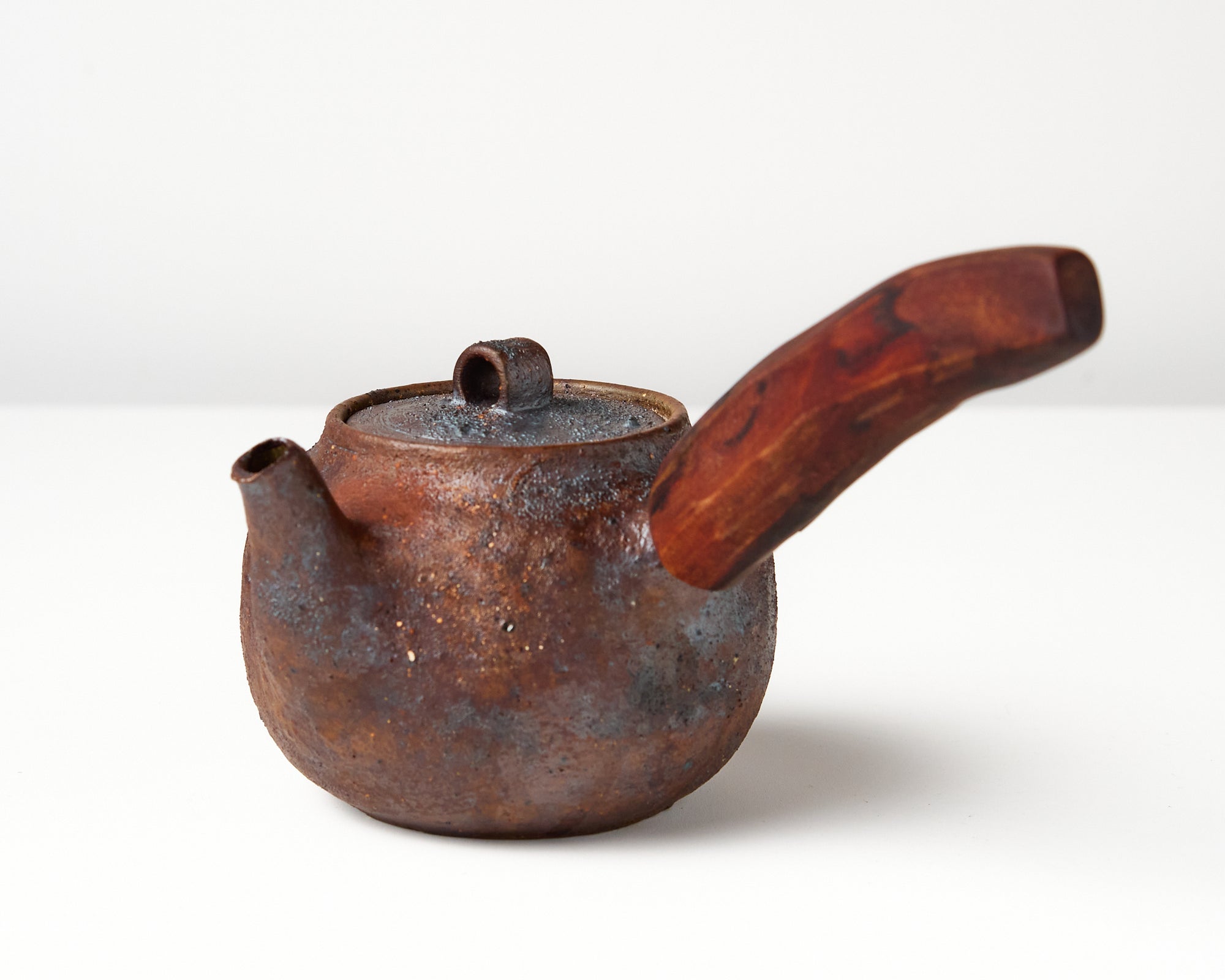 Side handle tea pot with wooden handle on white background. angled view 