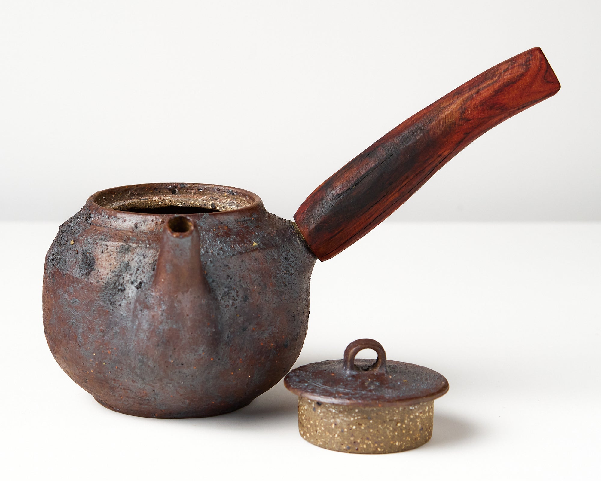 Side handle tea pot with wooden handle on white background. front view with lid off