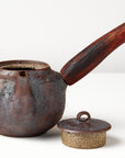 Side handle tea pot with wooden handle on white background. front view with lid off
