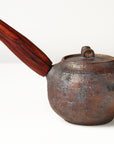 Side handle tea pot with wooden handle on white background. back view 