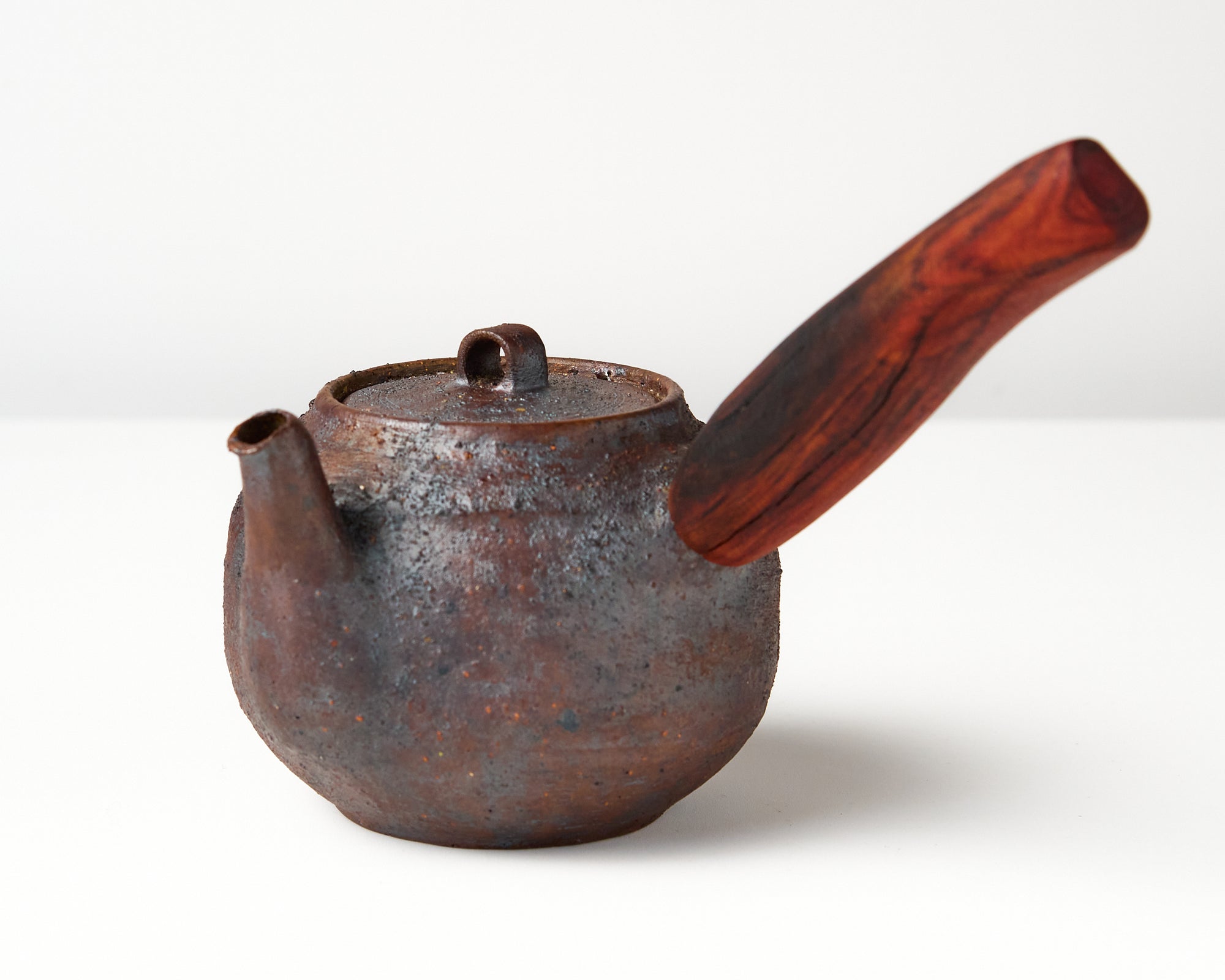 Side handle tea pot with wooden handle on white background. angled view 
