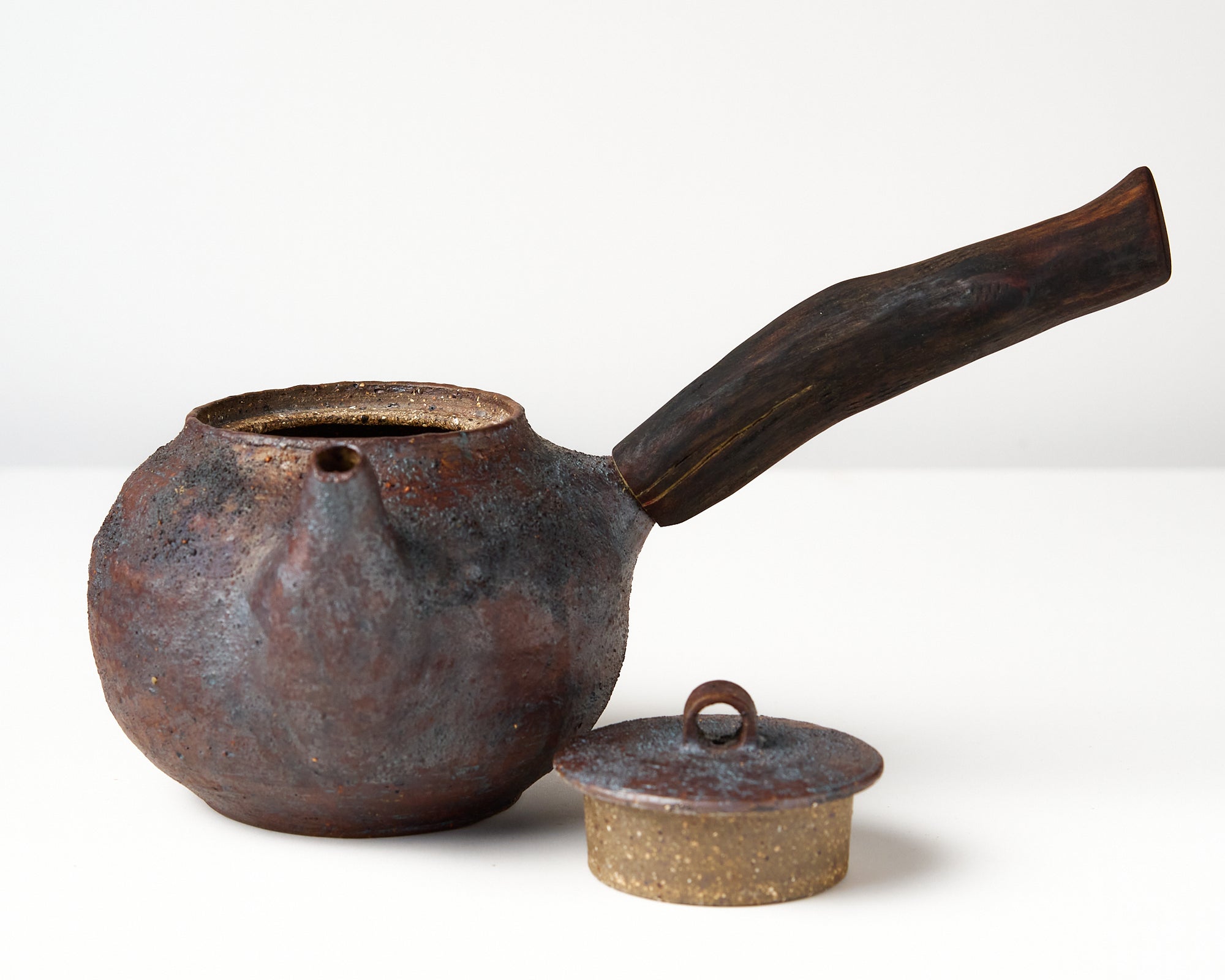 Side handle tea pot with wooden handle on white background. front view with lid off