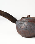 Side handle tea pot with wooden handle on white background. back view 