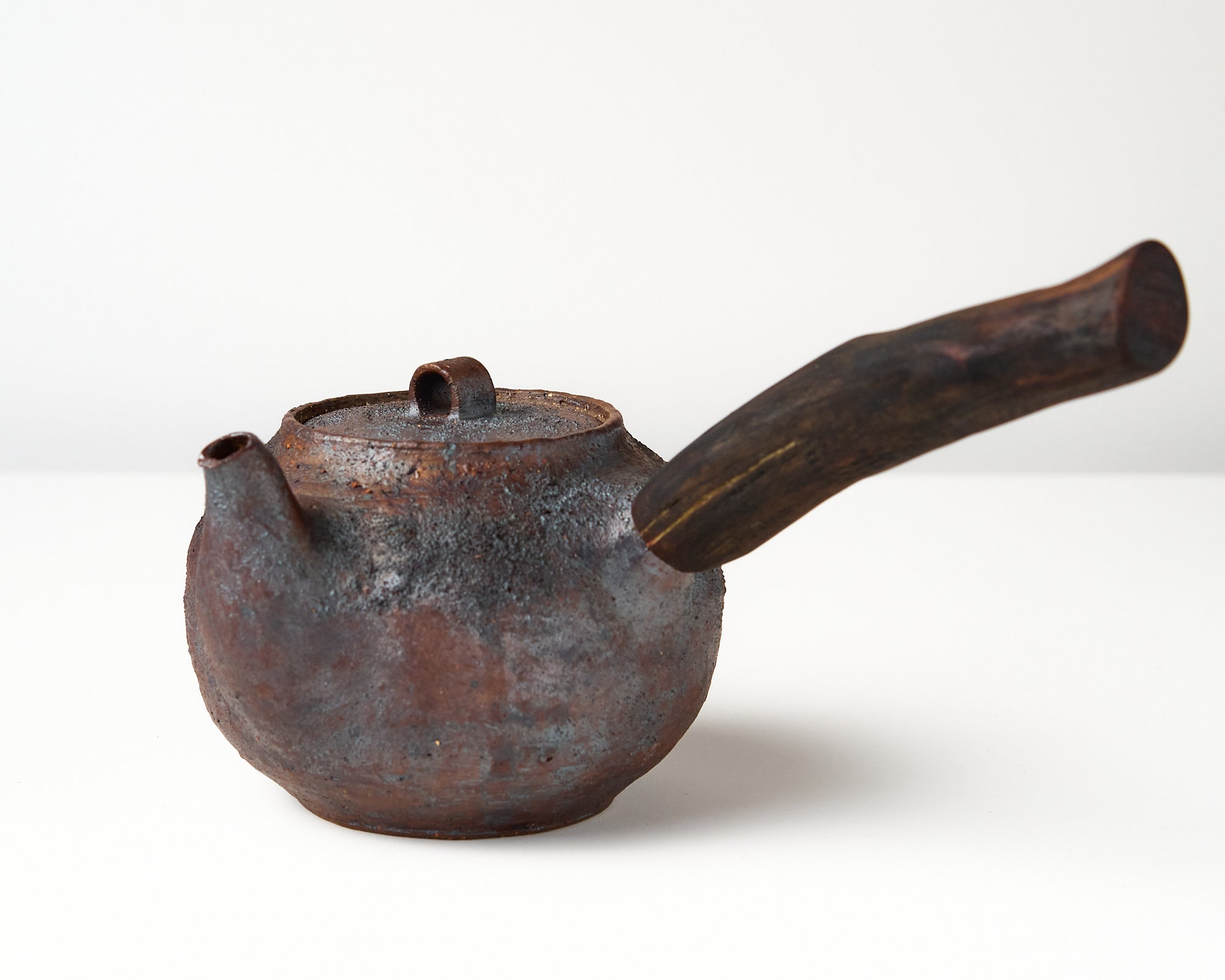Side handle tea pot with wooden handle on white background. angled view 