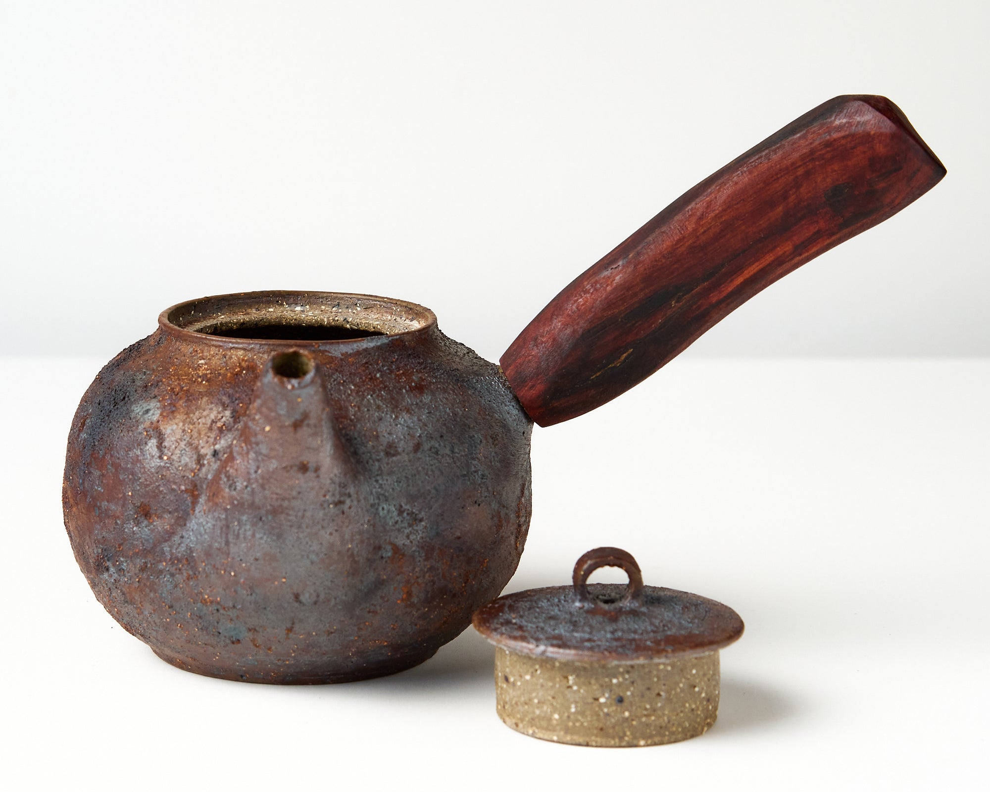 Side handle tea pot with wooden handle on white background. front view with lid off