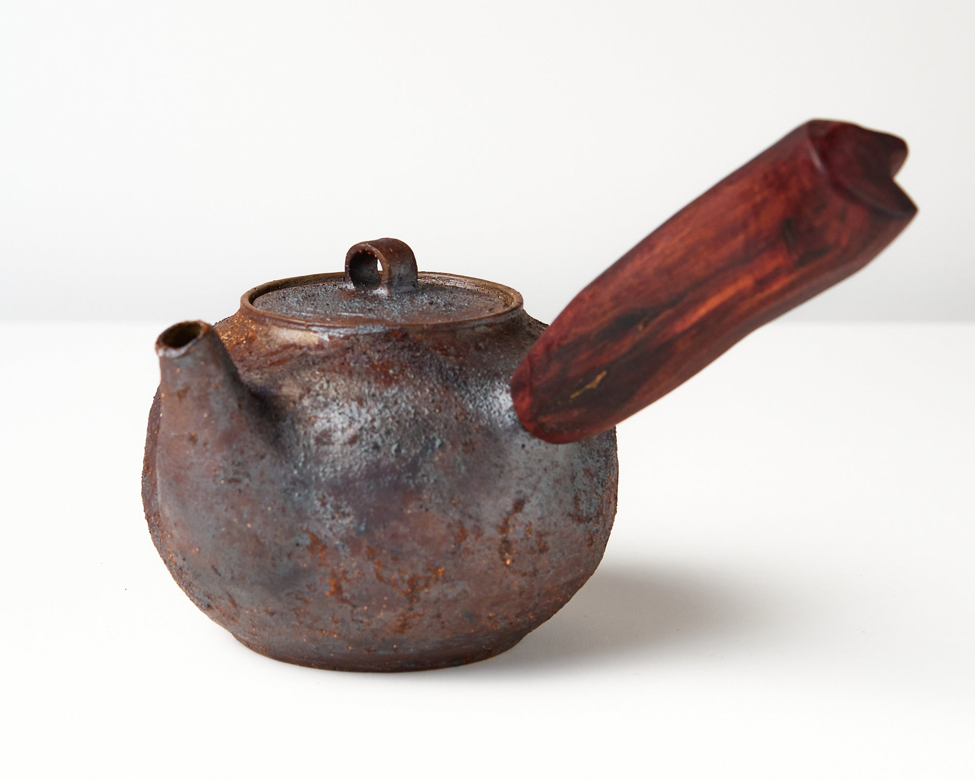 Side handle tea pot with wooden handle on white background. angled view 