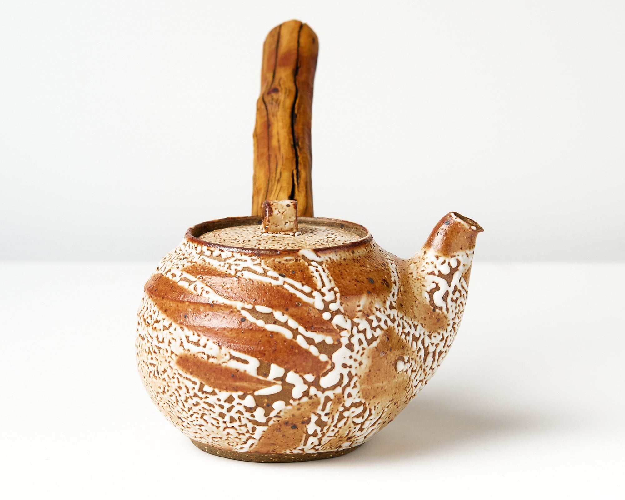 Ceramic teapot with wooden handle on a white background, side view